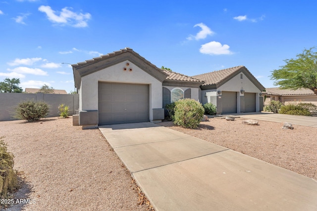 5529 E Holmes Ave, Mesa, AZ 85206 - mediterranean / spanish-style house with stucco siding, concrete driveway, a tiled roof, and a garage