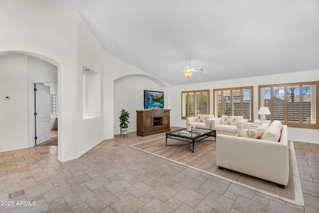 5529 E Holmes Ave, Mesa, AZ 85206 - living room featuring ceiling fan, arched walkways, stone finish floors, a fireplace, and high vaulted ceiling