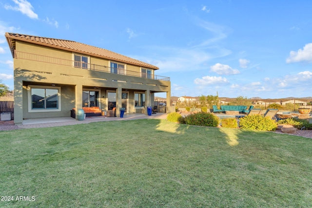 rear view of property with a lawn and a patio