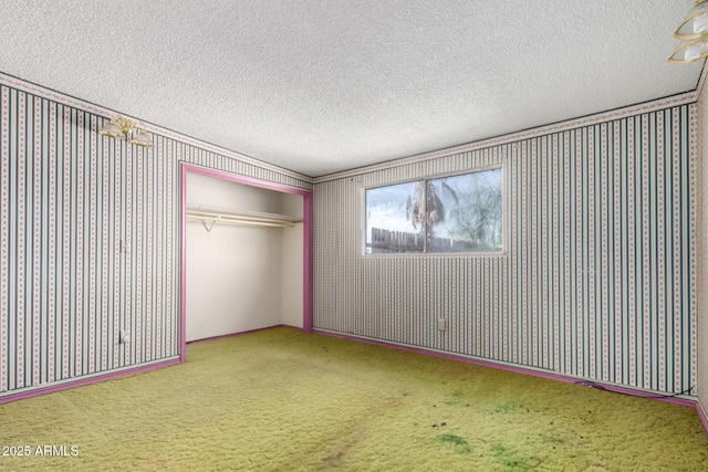 unfurnished bedroom with wallpapered walls, a closet, carpet floors, and a textured ceiling