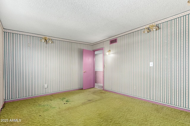 unfurnished room with wallpapered walls, visible vents, carpet, and a textured ceiling