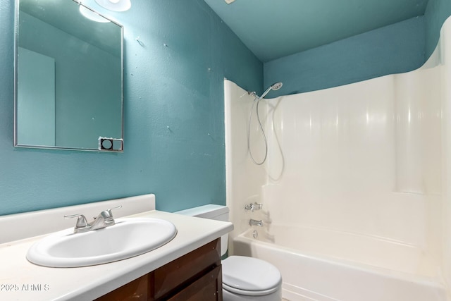 bathroom featuring toilet, vanity, and bathtub / shower combination