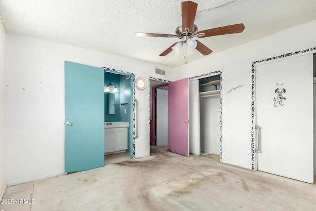 unfurnished bedroom with visible vents, ensuite bath, a closet, a textured ceiling, and a sink