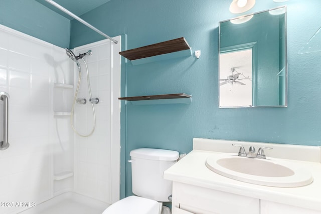 bathroom featuring a shower stall, toilet, and vanity