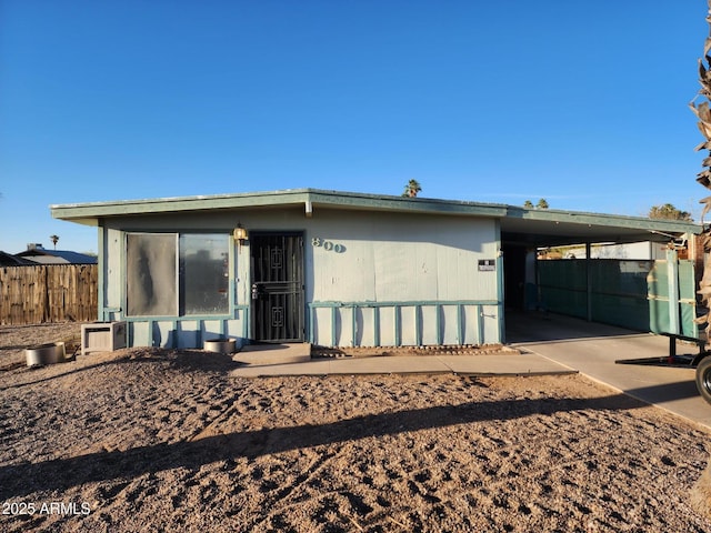 manufactured / mobile home featuring an attached carport, driveway, and fence