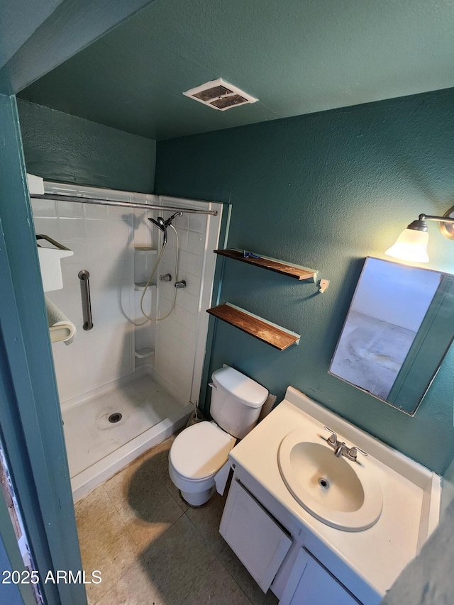 bathroom featuring visible vents, a shower stall, vanity, and a textured wall