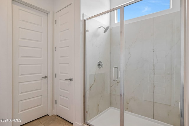 bathroom with tile flooring and walk in shower