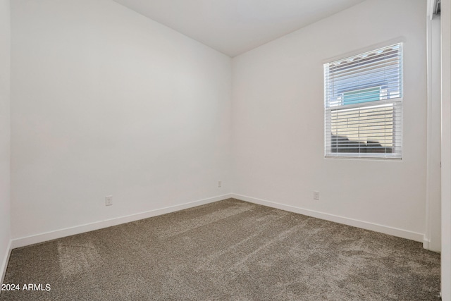 unfurnished room featuring dark colored carpet