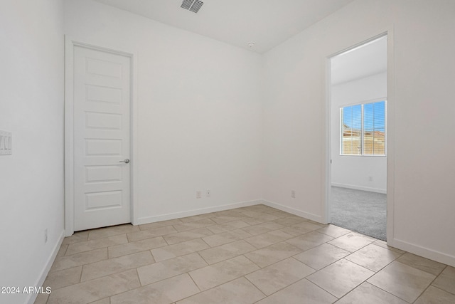 unfurnished room with light tile flooring