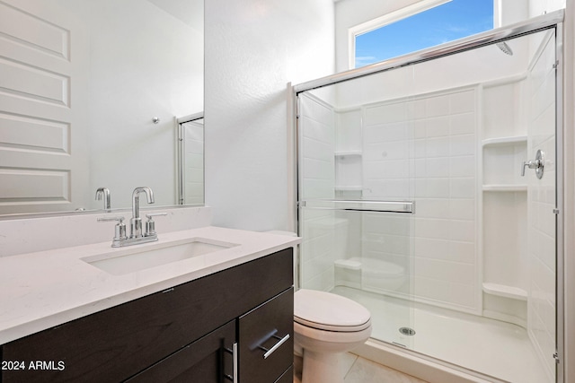 bathroom with tile floors, toilet, vanity, and an enclosed shower