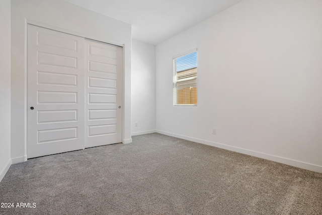 unfurnished bedroom with a closet and light carpet