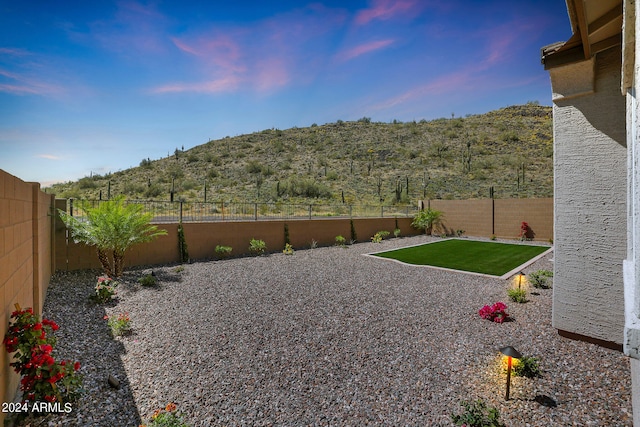 yard at dusk featuring a mountain view