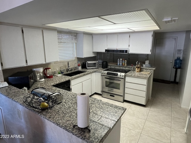 kitchen with a peninsula, stainless steel range, a sink, and white cabinets