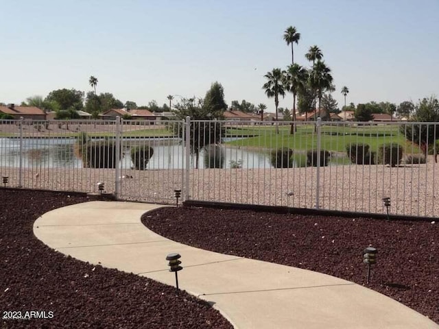 view of yard featuring a gate, a water view, and fence