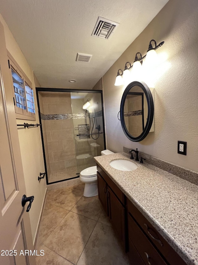 bathroom featuring an enclosed shower, vanity, a textured ceiling, tile patterned floors, and toilet