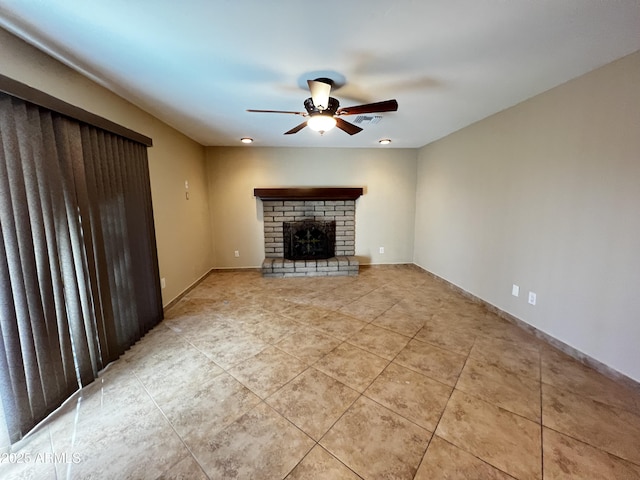 unfurnished living room with a brick fireplace, light tile patterned floors, and ceiling fan