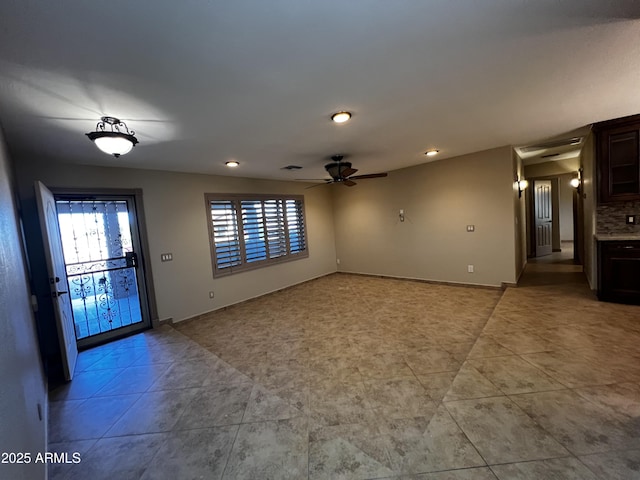 empty room with light tile patterned floors, a wealth of natural light, and ceiling fan