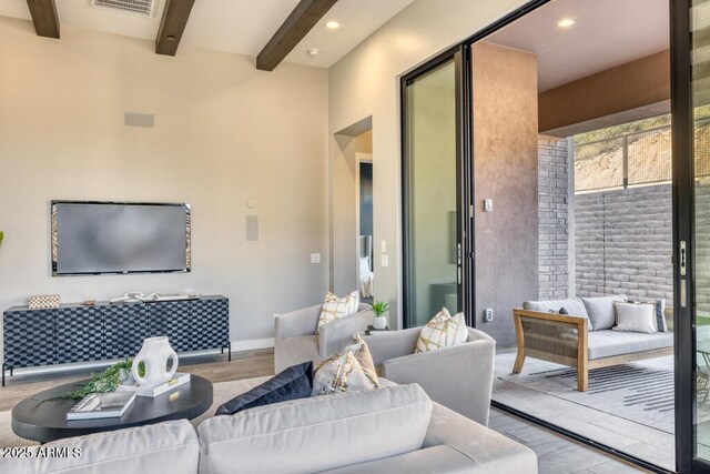 living room with beam ceiling, recessed lighting, wood finished floors, and visible vents