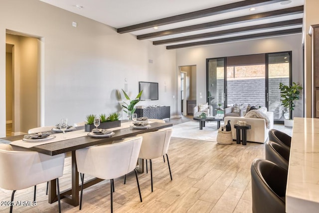 dining space with beamed ceiling and light wood finished floors