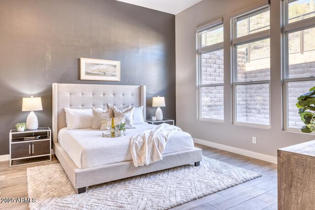 bedroom with baseboards and wood finished floors