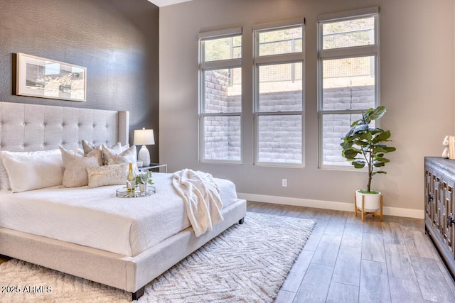 bedroom featuring baseboards and wood finished floors