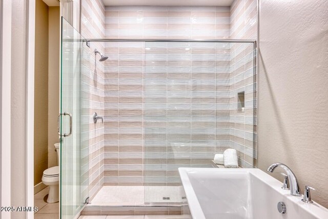 bathroom with a sink, a shower stall, tile patterned floors, toilet, and a textured wall