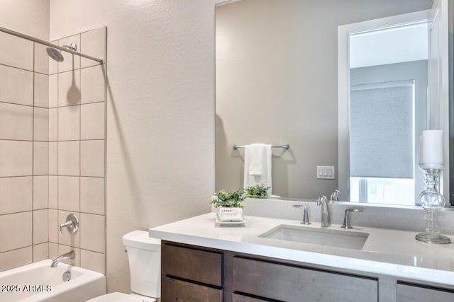 full bathroom with vanity, toilet, tub / shower combination, and a textured wall