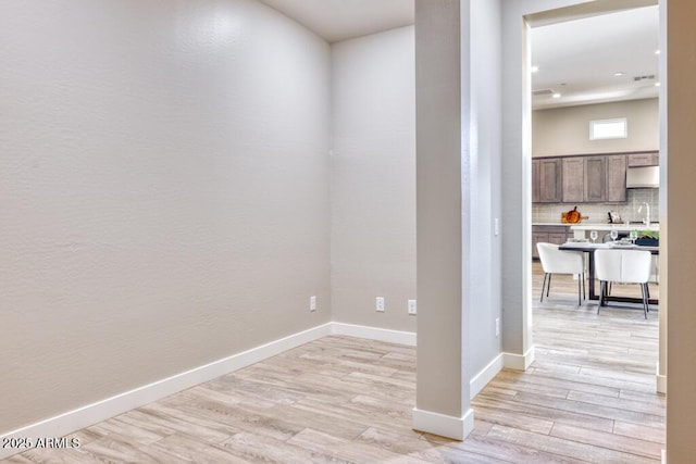 interior space with baseboards and light wood-style floors