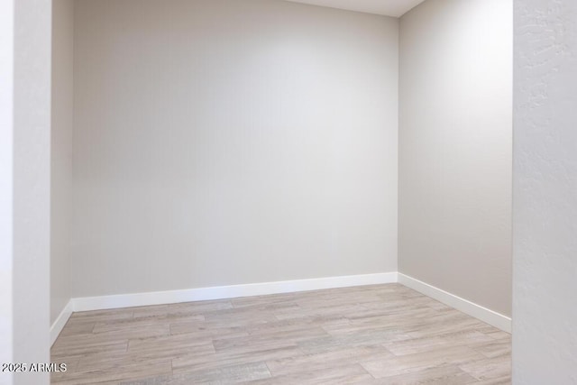 empty room with baseboards and light wood-style floors