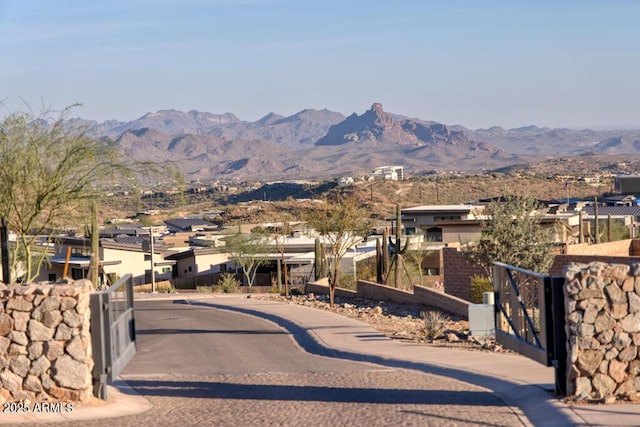 exterior space featuring a residential view, a mountain view, fence, and a gate