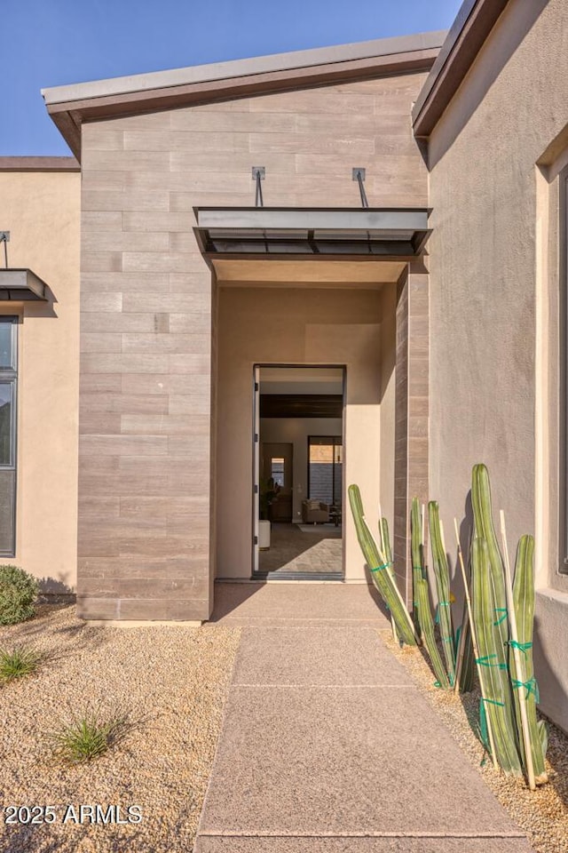 entrance to property featuring stucco siding