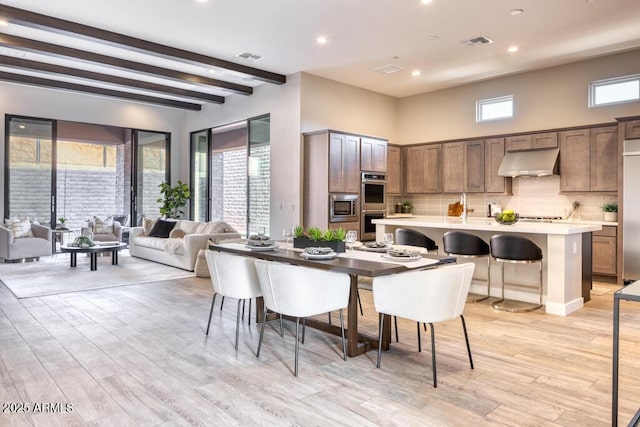 dining room featuring recessed lighting, visible vents, light wood-style floors, and beamed ceiling