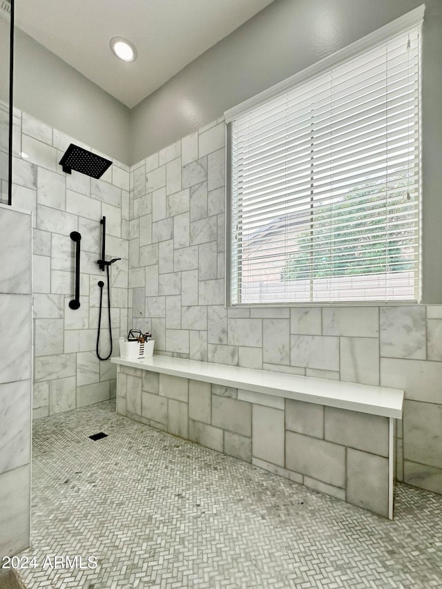 bathroom with a healthy amount of sunlight and tiled shower