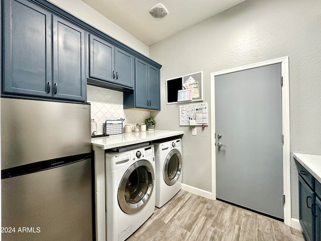 laundry room with cabinets, separate washer and dryer, and light hardwood / wood-style flooring