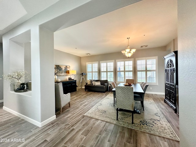 dining room with a notable chandelier, light hardwood / wood-style floors, and a wealth of natural light