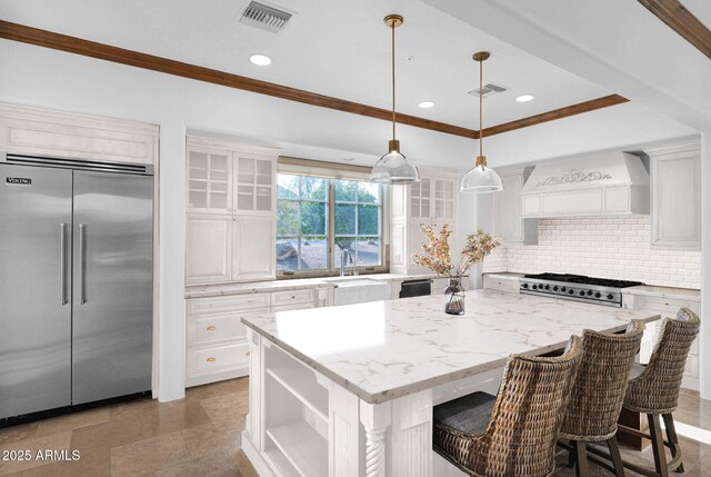 kitchen featuring pendant lighting, ceiling fan, a center island, and a healthy amount of sunlight