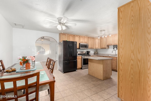 kitchen featuring appliances with stainless steel finishes, a center island, light tile patterned floors, and light brown cabinets