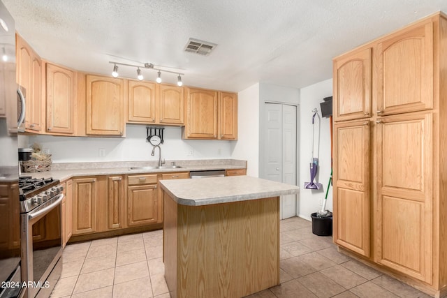 kitchen with a textured ceiling, a center island, sink, and stainless steel appliances