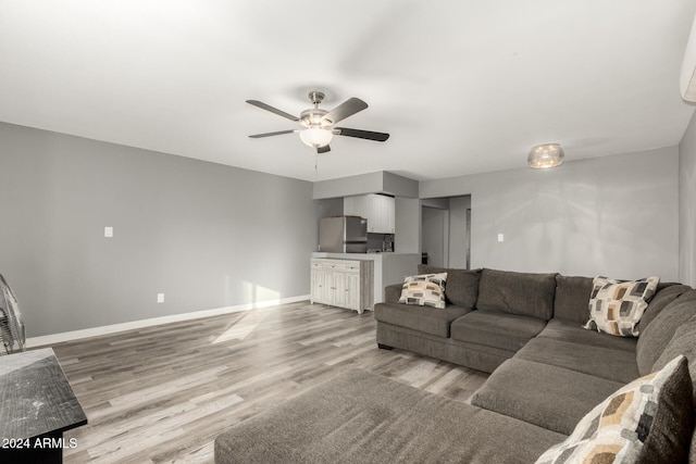 living room with light hardwood / wood-style floors and ceiling fan