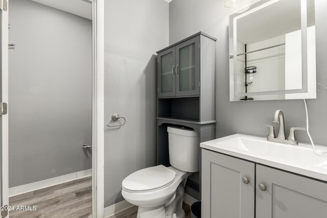 bathroom with hardwood / wood-style flooring, vanity, and toilet