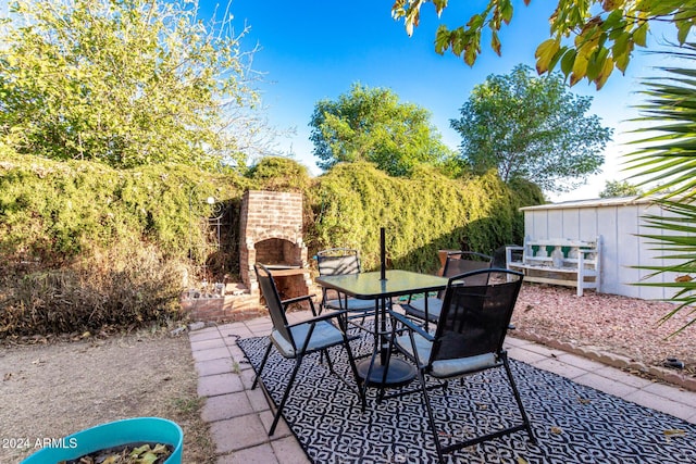 view of patio with an outdoor brick fireplace