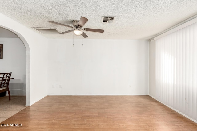 empty room with a textured ceiling, light hardwood / wood-style flooring, and ceiling fan