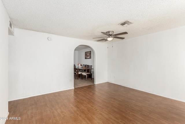 unfurnished room with ceiling fan, hardwood / wood-style floors, and a textured ceiling