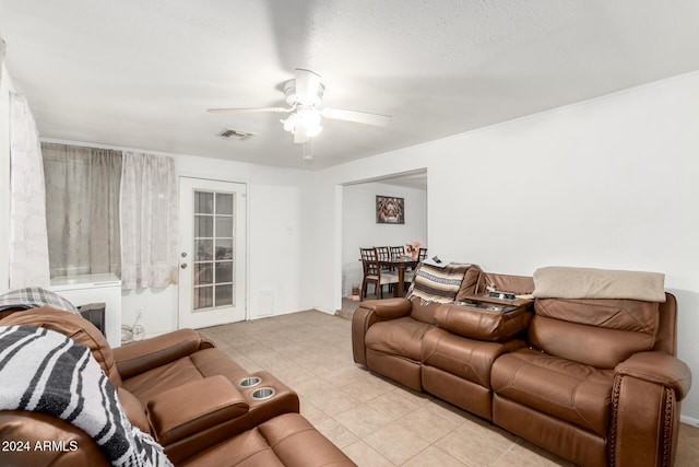 living room featuring ceiling fan, light tile patterned floors, and a textured ceiling