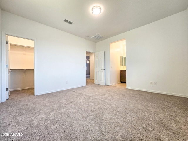 19954 W Moonlight Path, Buckeye, AZ 85326 - unfurnished bedroom featuring carpet flooring, baseboards, a spacious closet, ensuite bathroom, and a closet