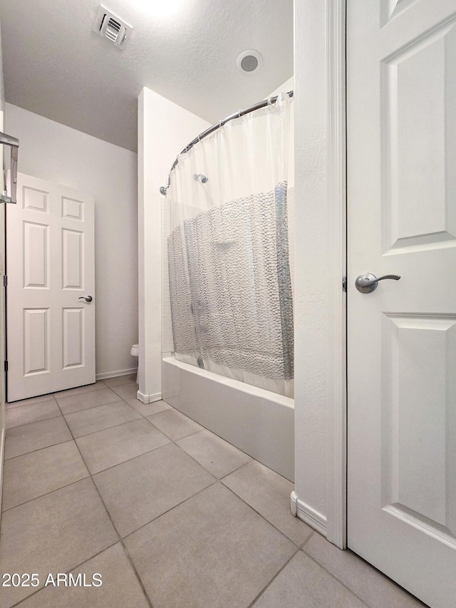 19954 W Moonlight Path, Buckeye, AZ 85326 - bathroom featuring tile patterned floors, shower / bath combo, toilet, and baseboards