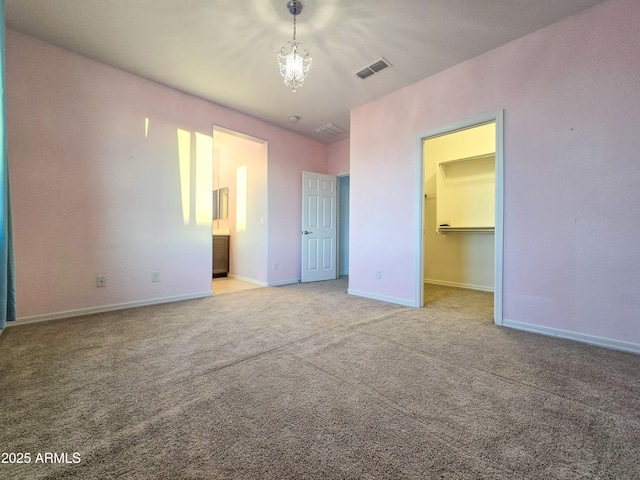 19954 W Moonlight Path, Buckeye, AZ 85326 - unfurnished bedroom featuring a walk in closet, carpet, baseboards, and connected bathroom