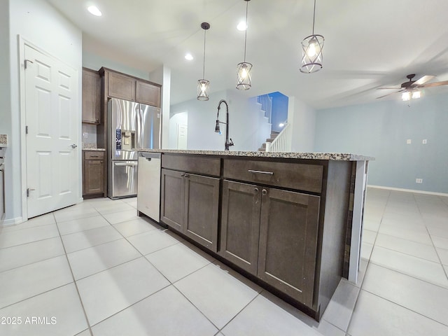 19954 W Moonlight Path, Buckeye, AZ 85326 - kitchen with appliances with stainless steel finishes, ceiling fan, light tile patterned flooring, baseboards, and a center island with sink