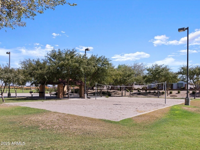 surrounding community with volleyball court and a lawn