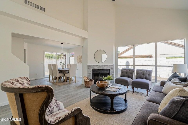 living room with light hardwood / wood-style flooring and a high ceiling